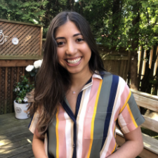 Woman with long dark hair wearing a striped shirt smiling