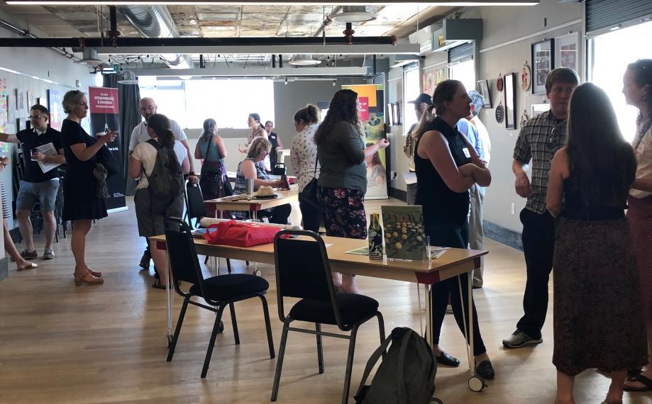 About 20 people networking in a large room