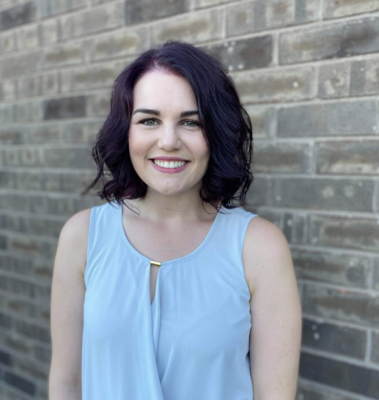 Photo shows Tanja Samardzic; woman with short purple hair wearing a blue shirt.