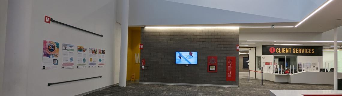 Photo of five posters displayed on a white wall in the lobby of the Athletic Centre