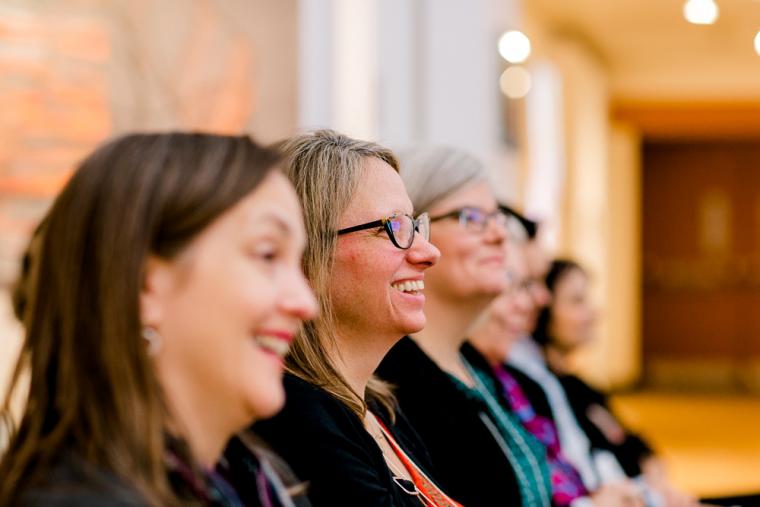 Row of event attendees looking to the right and smiling.