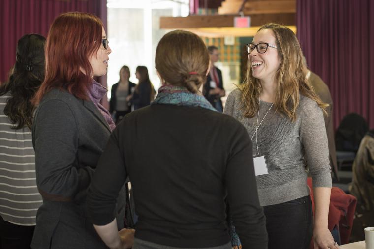 Three participants at an event organized by CESI are standing and having an engaged conversation.