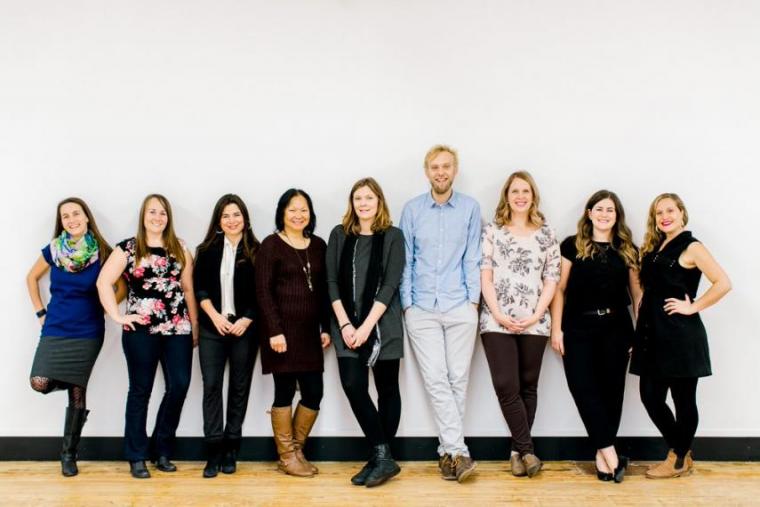 All 9 CESI staff members pose in front of a white wall