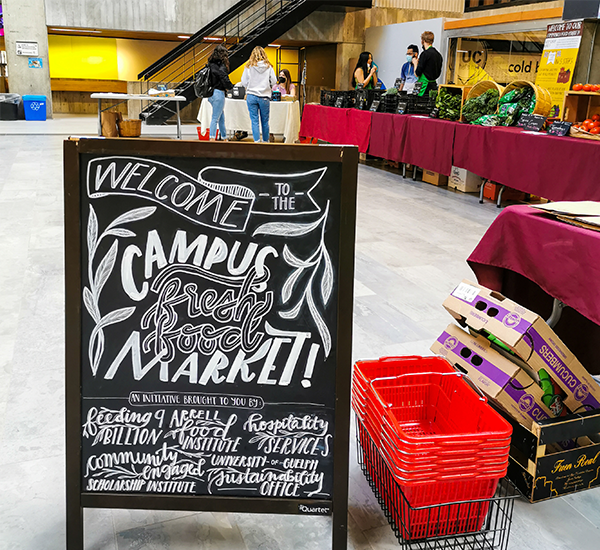 a sandwich board reads welcome to the campus fresh food market