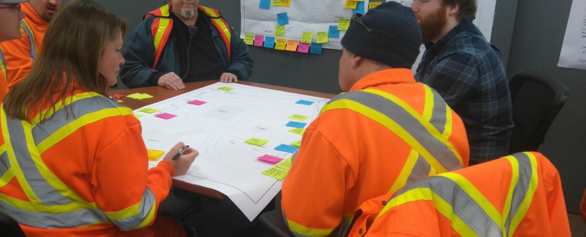 group of adults gathered around table working on a city planning activity